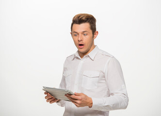 a man in a white shirt uses a tablet on a white isolated background.close-up portrait of a man with a tablet emotionally