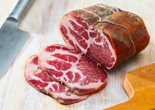 Appetizing sliced jerky boneless pork tenderloin on wooden background. Meat snack