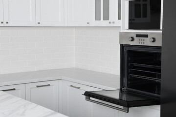 Modern oven and microwave in white clean kitchen