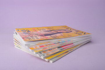 Group of stacked magazines on violet background