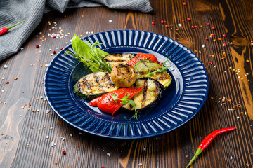 grilled vegetables on a blue plate on wooden table
