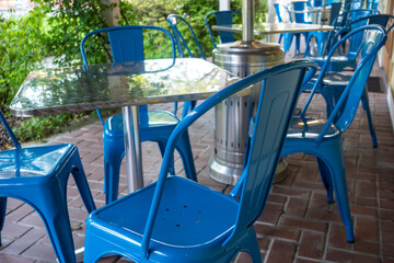 Colorful view of bright blue chairs gathered around a blue table on an outdoor patio at a restaurant