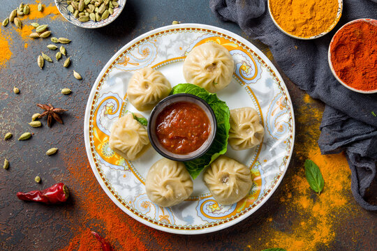Indian food Momo with meat and tomato sauce on dark blue table top view