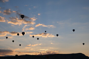 Lots of hot air balloons silhouette at sunrise in the cloudy sky at Cappadocia Turkey. Copy space area.
