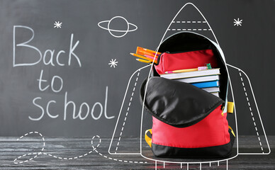 Drawn rocket with backpack and stationery against blackboard with text BACK TO SCHOOL