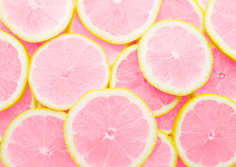 Many slices of unusual pink lemon as background