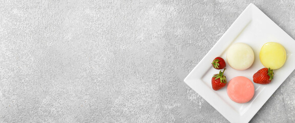 Plate with tasty Japanese mochi and strawberry on light background with space for text