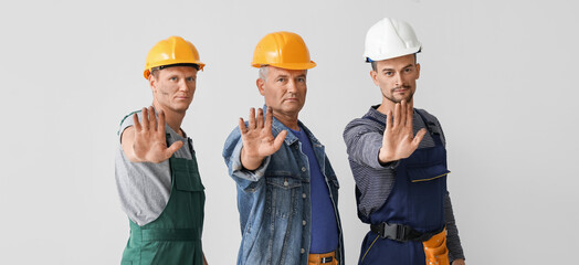 Miner men showing STOP gesture on grey background