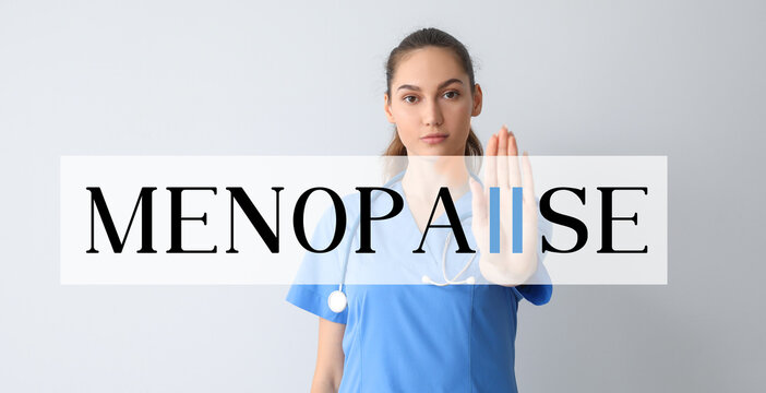 Female doctor showing word MENOPAUSE on light background