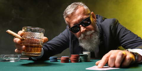 Mature businessman playing poker in casino