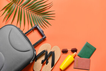 Suitcase and different traveler accessories on color background