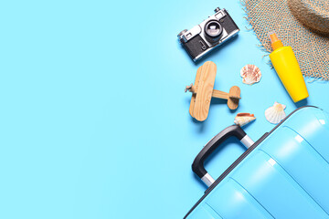 Traveler accessories and suitcase on blue background
