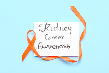 Paper sheet with text KIDNEY CANCER AWARENESS with orange ribbon on blue background
