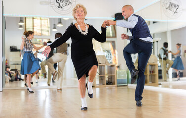 Mature woman dancing swing with young man