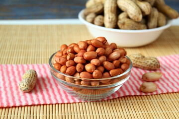 fresh organic whole and peeled peanut in bowl closeup