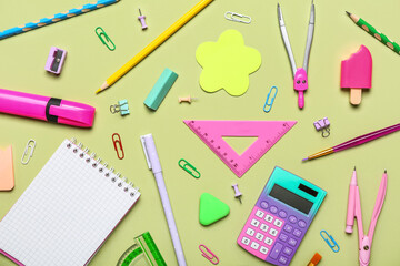 Different school stationery on green background, top view