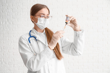 Female doctor with monkeypox vaccine and syringe on white background