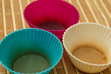 group of colored silicone molds for cupcake, in white, purple and blue colors