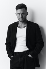 Fototapeta premium Modelling snapshots. Evil self-confident attractive handsome man in classic suit hold hand on pocket posing isolated in white studio background. Black and White concept. Fashion offer. Copy space
