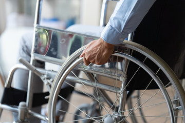 Businessman suffering from accident sickness in a wheelchair, sickness concept while working in the office.