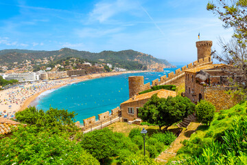 Hilltop castle view of the 12th Century castle and tower, wide sandy beach and historic whitewashed town of Tossa de Mar, on the Costa Brava coast of Catalunya, Spain.	