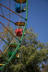 City amusement park. Ferris wheel with colored cabins.