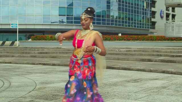 Amazing traditional Inian dance from a young girl in traditional Indian wear in a Caribbean city