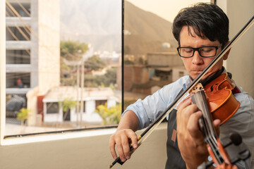 Photo with copy space of a man playing the violin to tuning it