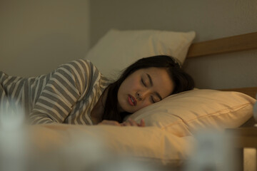 ベッドで眠る若い女性