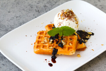 ice cream with waffles, fresh mint leaves, chocolate chips, topping and nuts