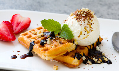 ice cream with Belgian waffles, strawberries, fresh mint, chocolate topping and nuts