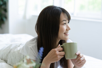 ベッドでスマホを見る女性
