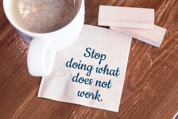 Stop doing what does not work advice or reminder - handwriting on a napkin with a cup of coffee
