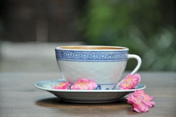 cup of coffee and plum flowers on the table