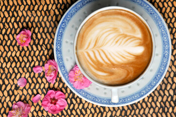 cup of coffee and plum flowers on the table