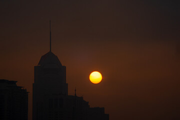 The sun rises next to the building