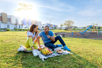 Beautiful Latin couple having a romantic breakfast with lots of tasty food and wine, sitting...