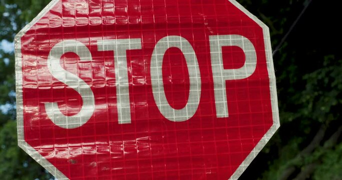 Road Construction Flagger Turning Sign from Slow to Stop While Directing Traffic
