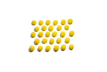 a lot of yellow round candies are laid out with a pattern on a white background