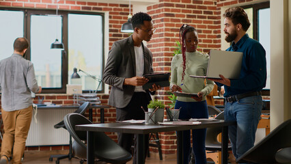 Multiethnic group of colleagues working on business research, analyzing online information on...