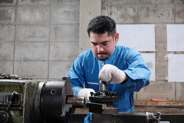 One professional Asian male industry engineer worker works in a safety uniform with metalwork...