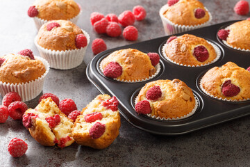 sweet raspberry muffins with white chocolate close-up in a muffin pan on the table. Horizontal - Powered by Adobe