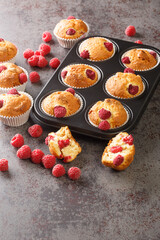 Fresh homemade delicious raspberry muffins closeup on the table. Vertical