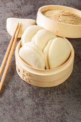 Gua bao, steamed buns in bamboo closeup, bao buns on the table. Vertical