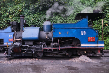 Fototapeta na wymiar DARJEELING, INDIA - JUNE 22, 2022, Close up detail of steam engine toy train of Darjeeling Himalayan railway at station, Darjeeling Himalayan railway is a UNESCO world heritage site.