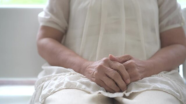 Unrecognizable Asian elder woman in stressed emotion.