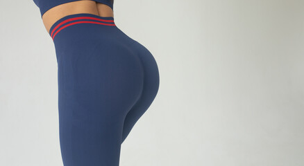 A big woman booty in leggings on grey background.