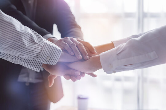 Business team standing hands together, Volunteer charity work. People join for cooperation success business. Panoramic teamwork business joins hand together concept,