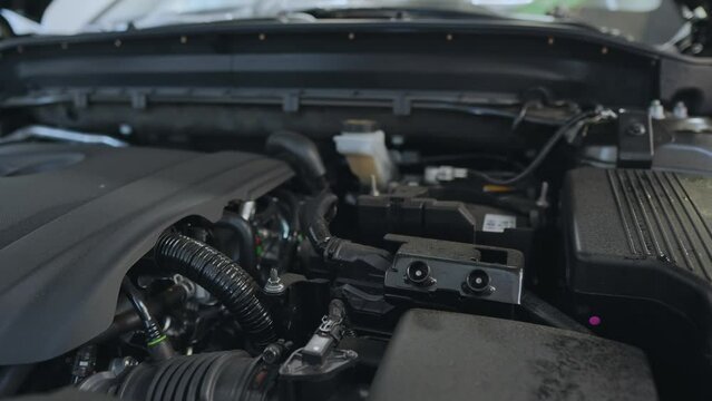 The engine compartment of a new car. Under the car hood: generator, engine, air filter, battery.