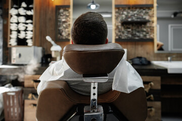 Young man client sitting in a barber shop